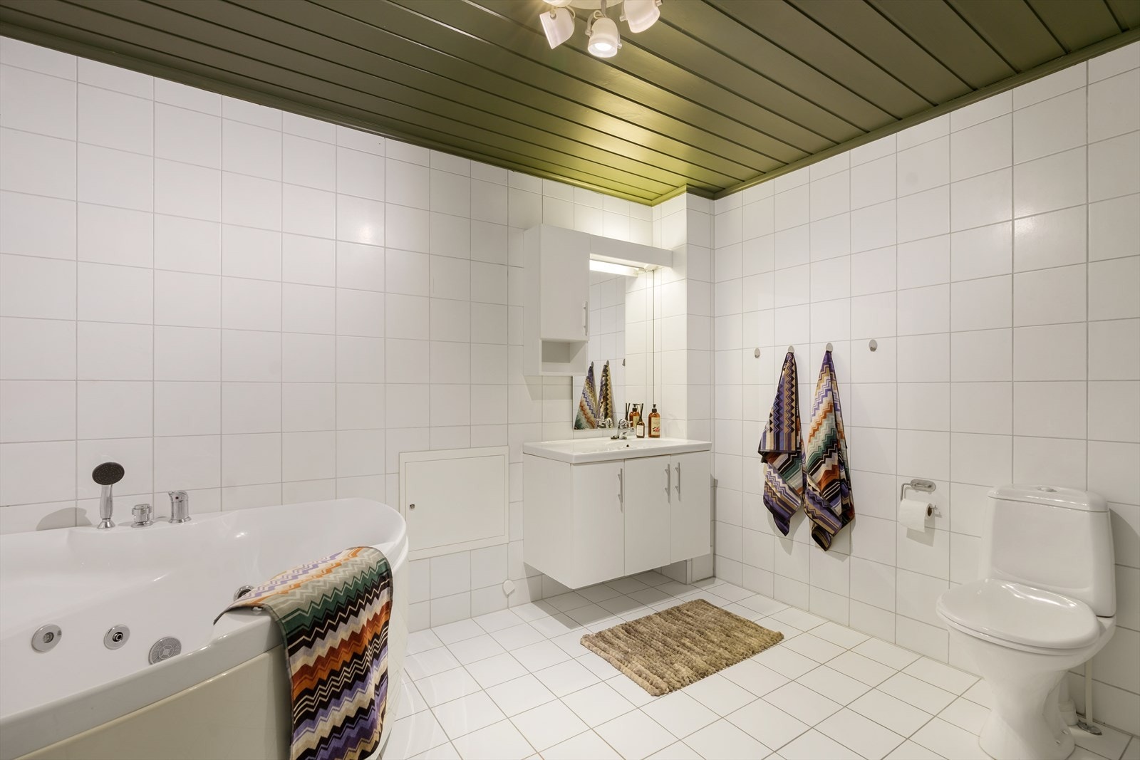 Stort bad med hjørnebadekar, dusjkabinett, baderomsseksjon og toalett Galleribilde