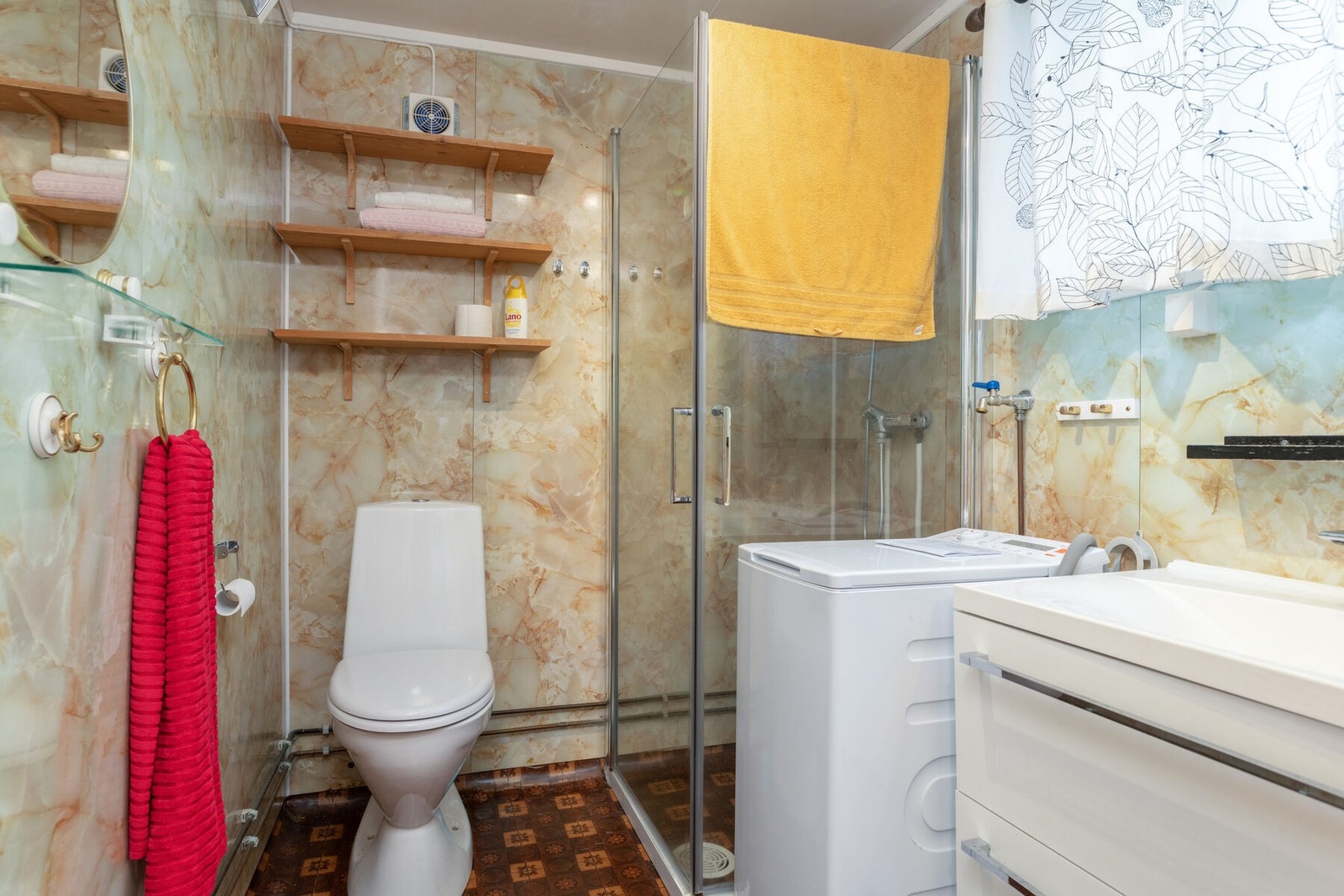 Eldre bad/vaskerom utstyrt med toalett, dusjhjørne, innredning med servant og opplegg for vaskemaskin. Galleribilde