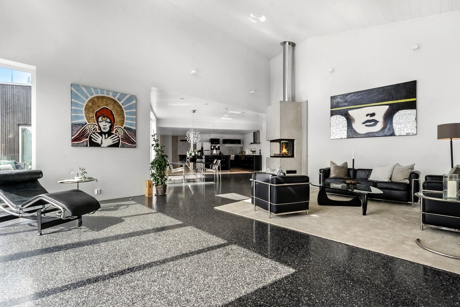 Lys og innbydende stue med terazzogulv og slette vegger malt i lyse fargetoner og en moderne listefri gjennomførelse. Galleribilde