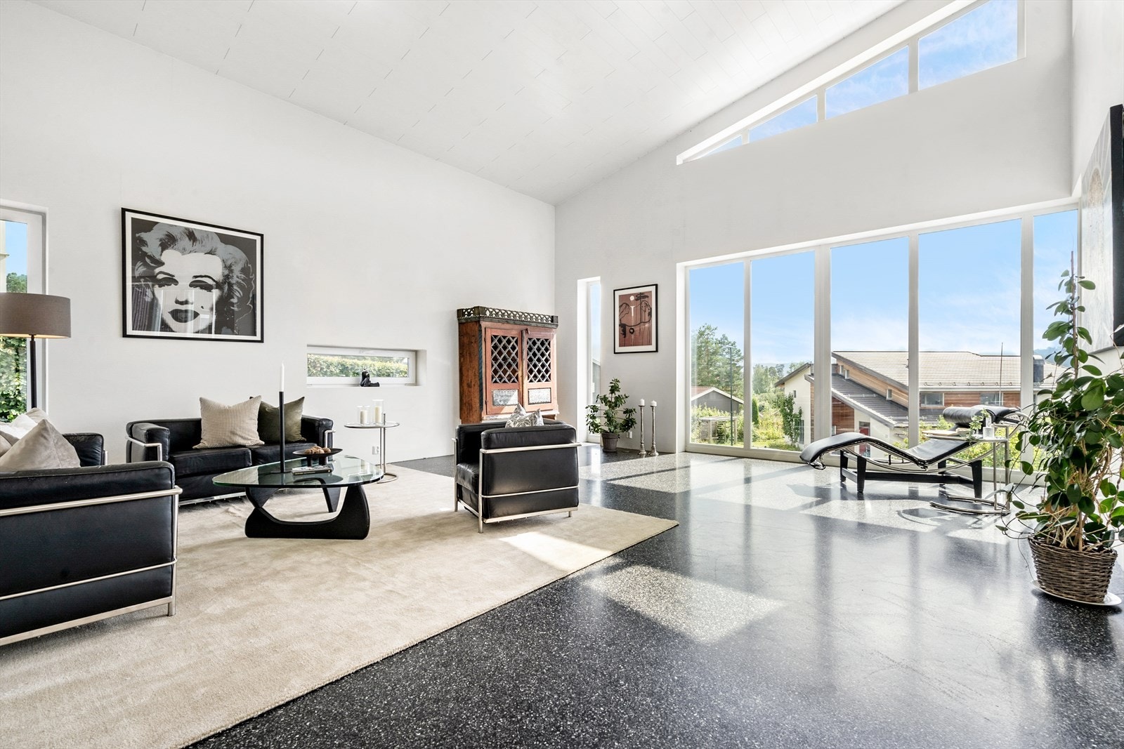 Stuen har en fantastisk takhøyde og preges av arkitektoniske vindusflater som strekker seg fra gulv til tak. Galleribilde