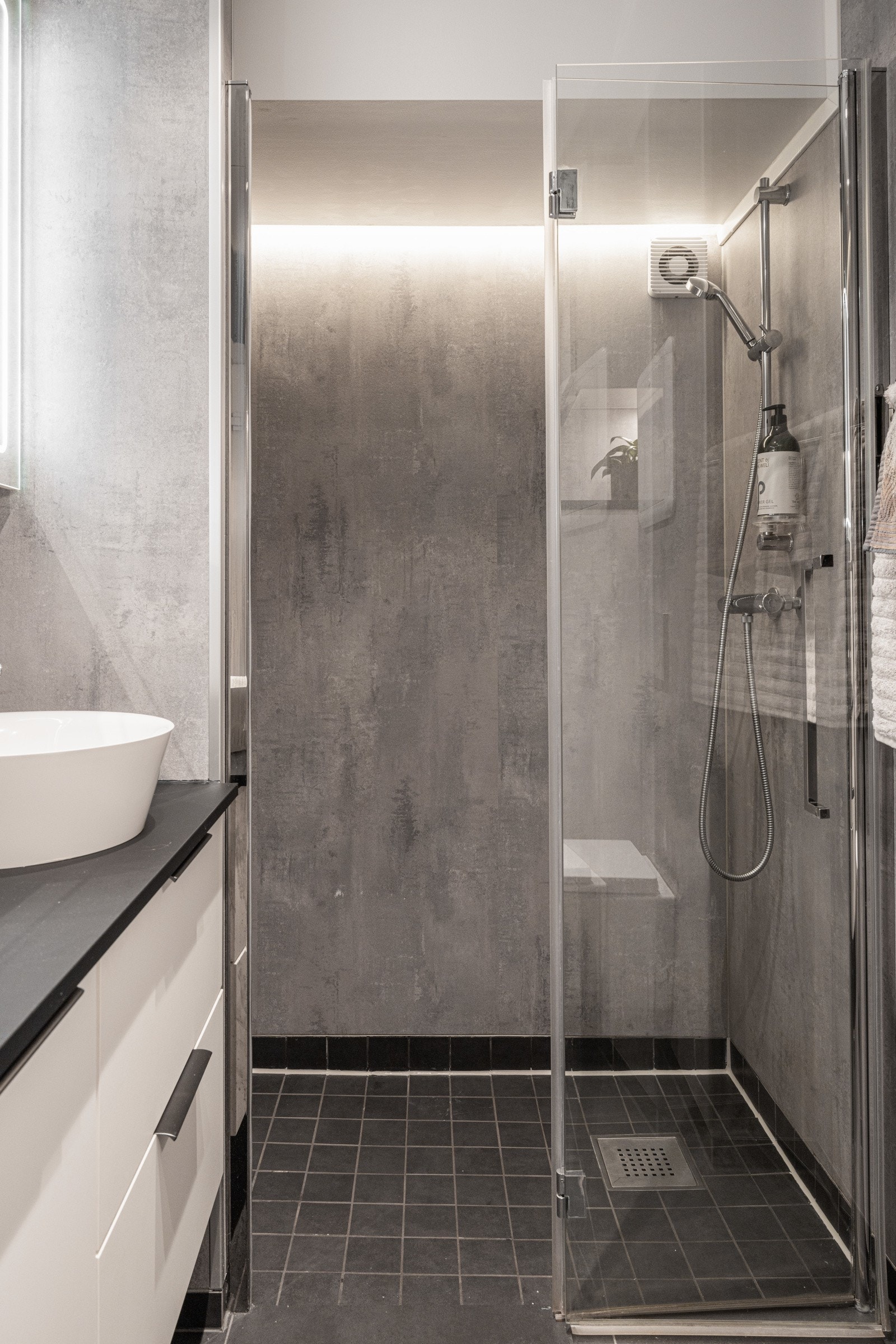 Det er innredet med egen dusjsone, vegghengt toalett, servant med innredning og speilskap med belysning. Galleribilde