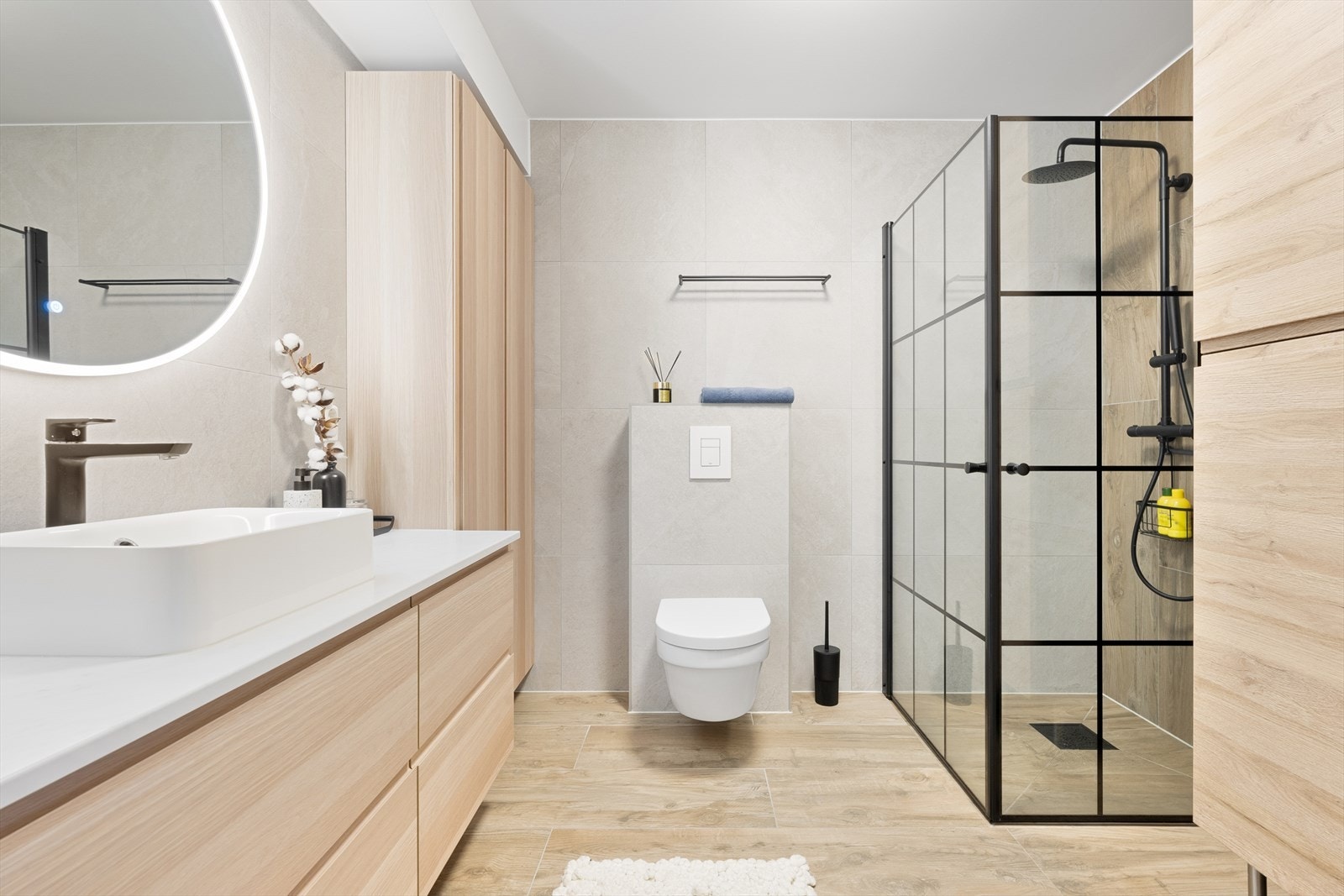 Badet har et dusjhjørne med sort regnfallsdusj og innfellbare glassdører i sort innramming. Galleribilde