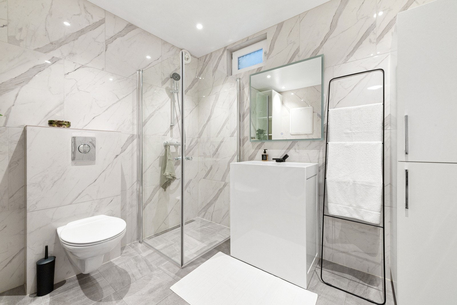 Badet er av den lekre sorten med stilrene fliser, lekker belysning og pent møblement. Galleribilde