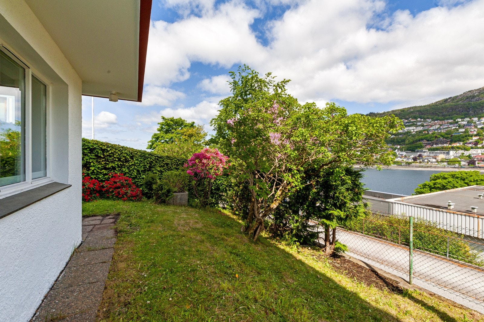 Utenfor leiligheten er det fine grøntareal, busker og beplantning. Et fint sted å sitte ute. Galleribilde
