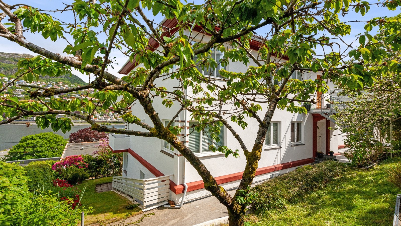 Tomten er pent opparbeidet med grønne arealer, busker og hage. Galleribilde