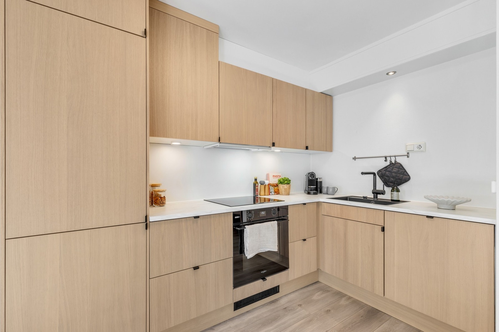 Utstyrt med plane fronter og laminerte benkeplater. Integrert platetopp, stekeovn, oppvaskmaskin og kjøl/fryseskap. Galleribilde