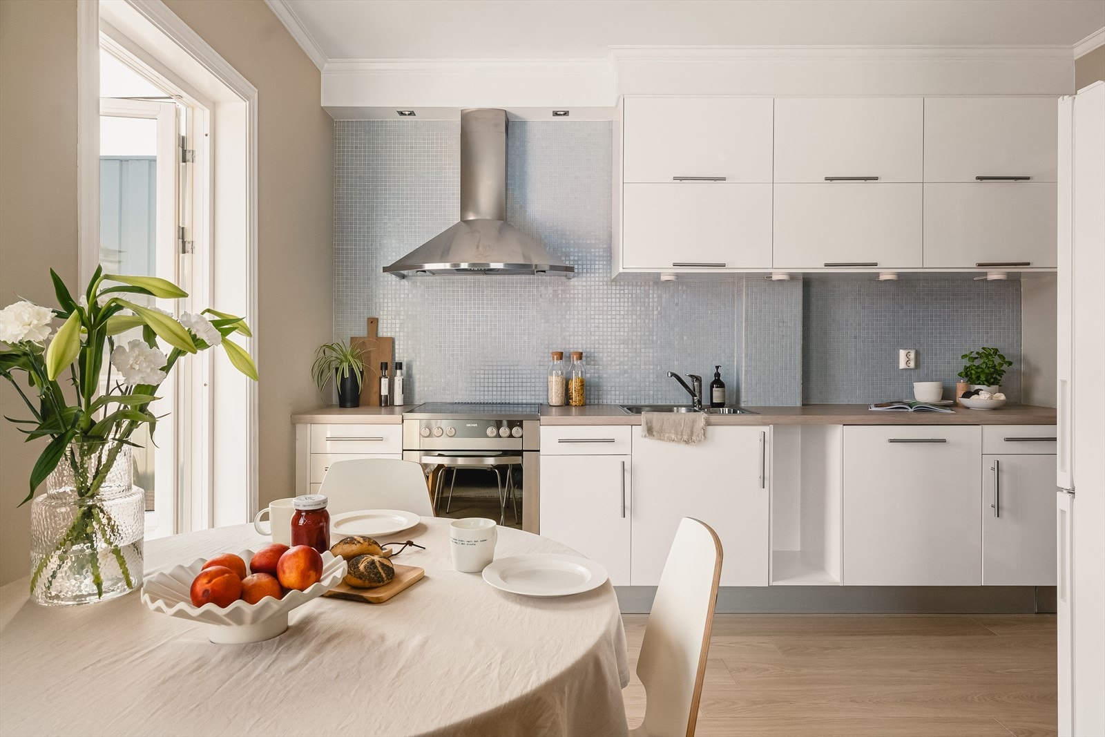 Stilren kjøkkeninnredning med glatte fronter og benkeplate av tre, foliert med laminatduk. Galleribilde