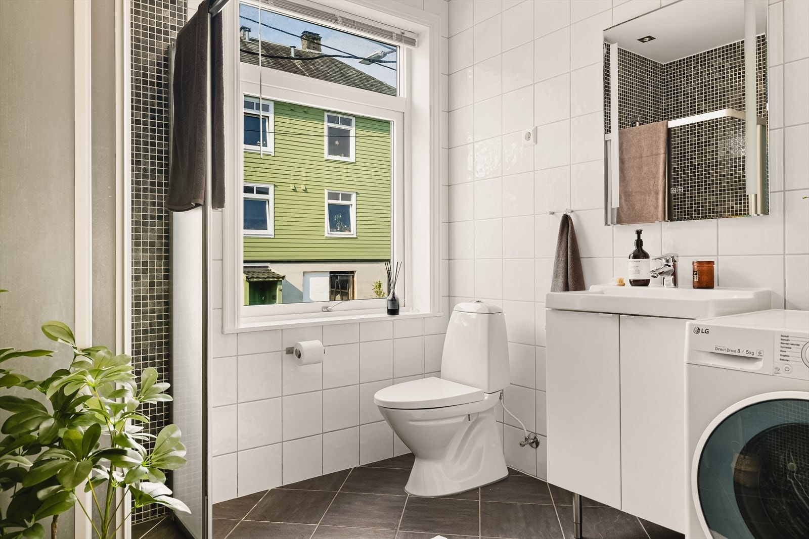 Her er servantinnredning med skuffer, speil med integrert lys, dusjhjørne med glassvegg og glassdør, vegghengt dusjarmatur og toalett. Galleribilde