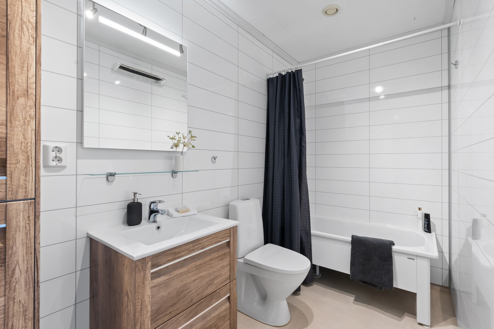 Pent bad med badekar, vegghengt servantskap med skuffeløsning og høyskap. Badet fikk oppgraderinger i 2016 Galleribilde