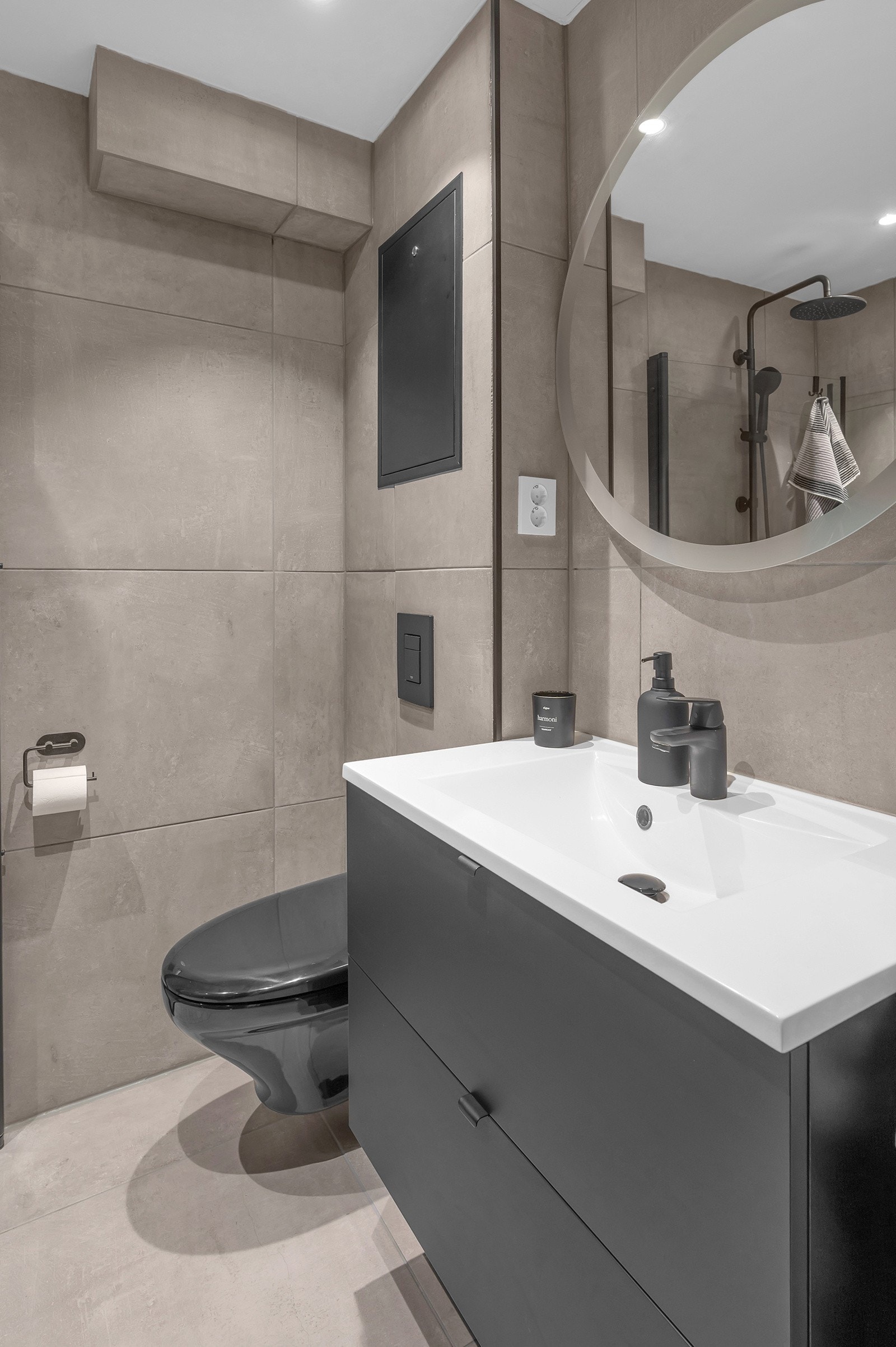 Her er det en gjennomgående stil med store fliser på gulv og vegger med spotter i tak. Galleribilde