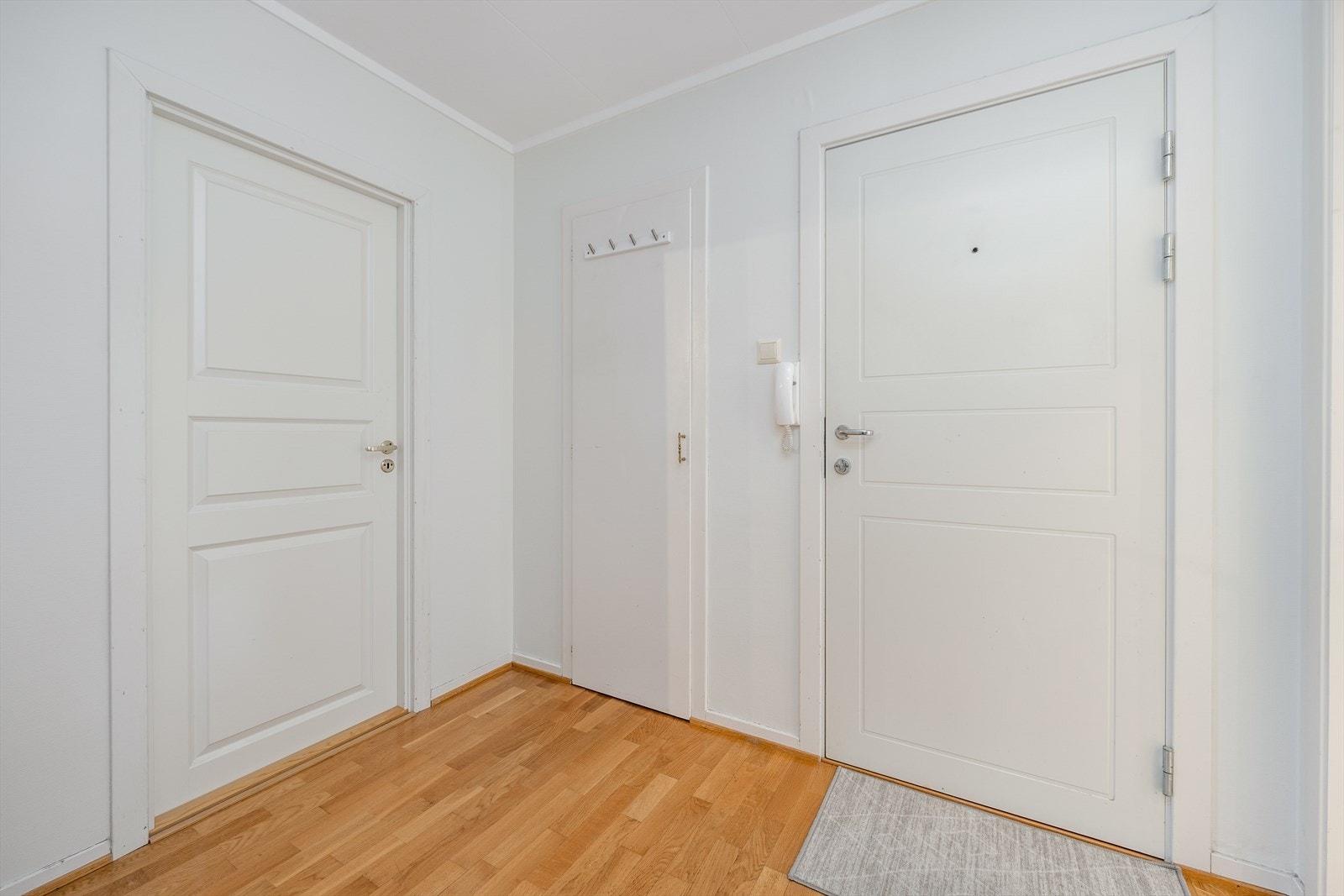 Callinganlegg ved hoveddør med felles trappegang opp til leilighetene. En hyggelig, lys entré ønsker deg velkommen inn i leiligheten hvor det er plass til sko og yttertøy. Galleribilde