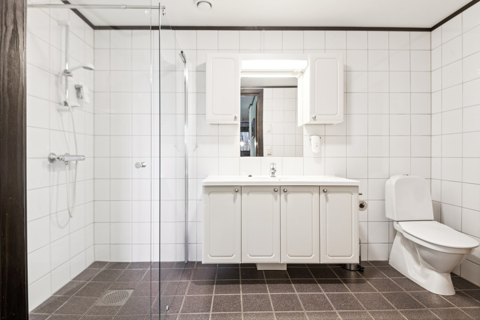 Romslig flislagt baderom med elektriske varmekabler Galleribilde