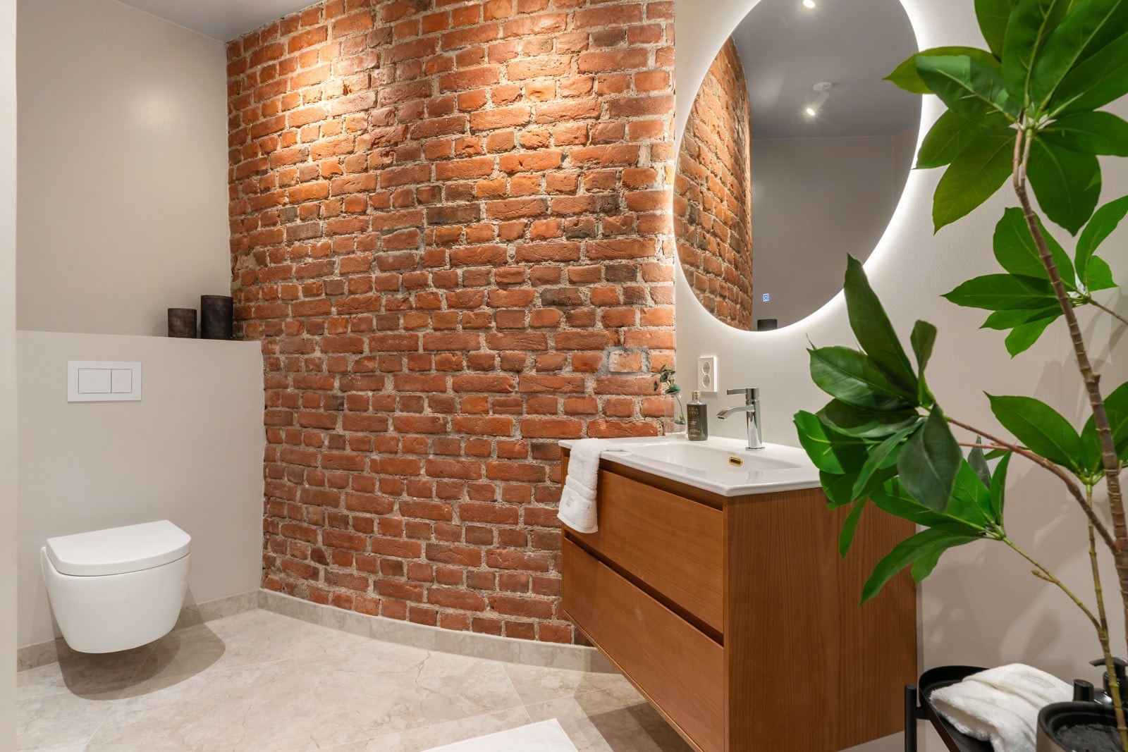 Baderommet med murvegg gir rommet en fin kombinasjon av moderne og rustikt design. Galleribilde