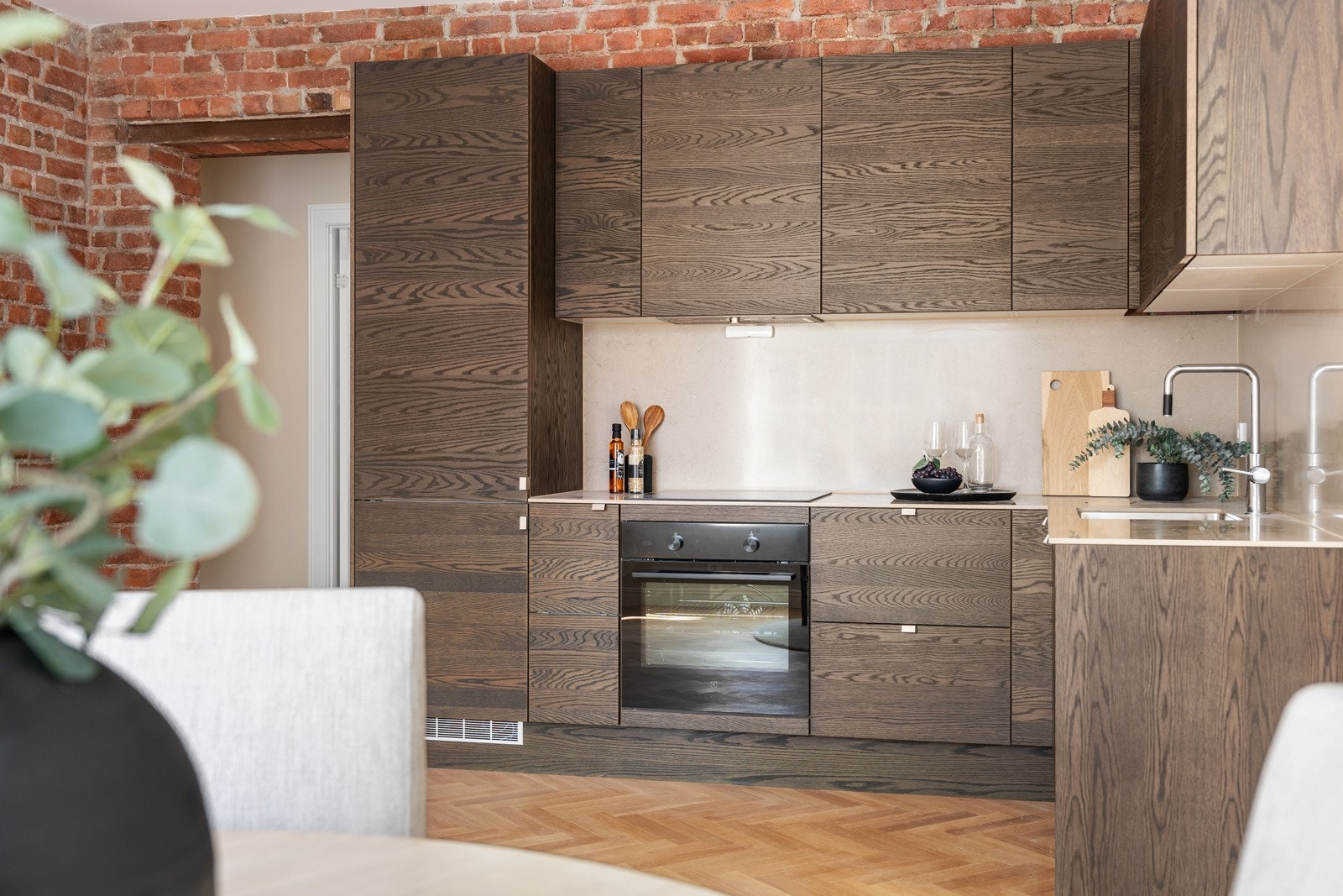 Kjøkkenet er lekkert designet med skapfronter i mørk eik og en lys benkeplate. Galleribilde