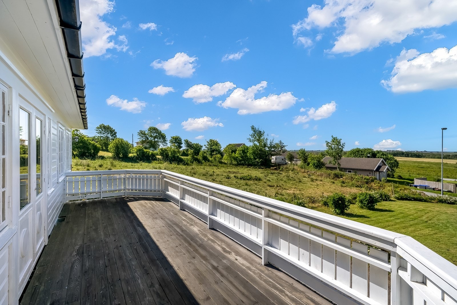Utgang fra stuen til en stor terrasse med plass til grill og utemøblement. Galleribilde