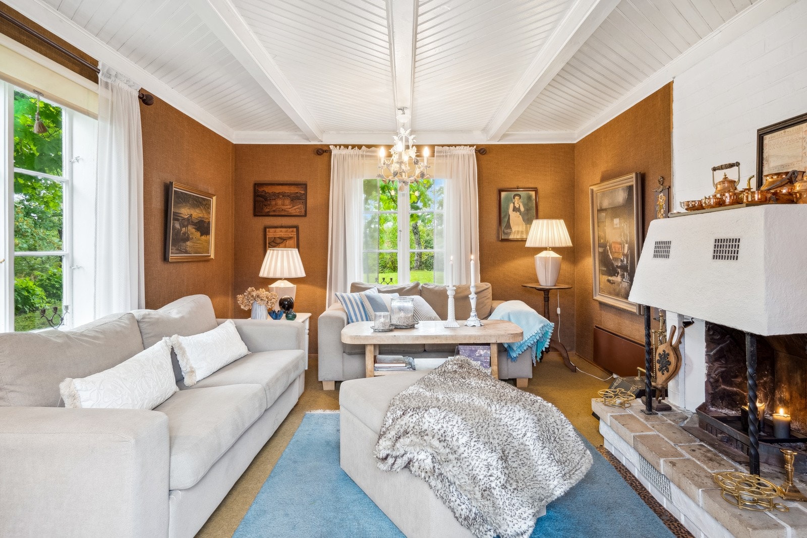 Stua bærer interiørmessige preg fra byggeår. Peisen er deilig for ekstra lune vinterkvelder. Galleribilde