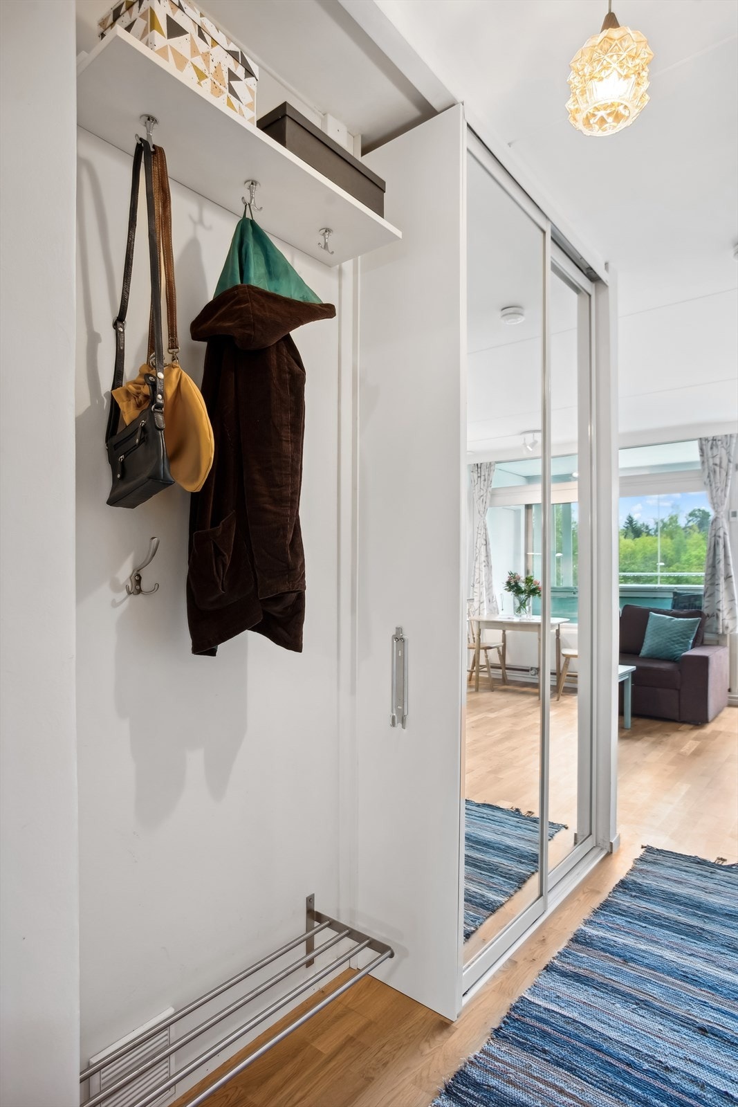 Her er det rikelig med plass til å henge fra seg yttertøyet og parkere skoene før du går videre inn i leiligheten. Entréen har også et praktisk skyvedørsgarderobe for oppbevaring av yttertøy. Galleribilde