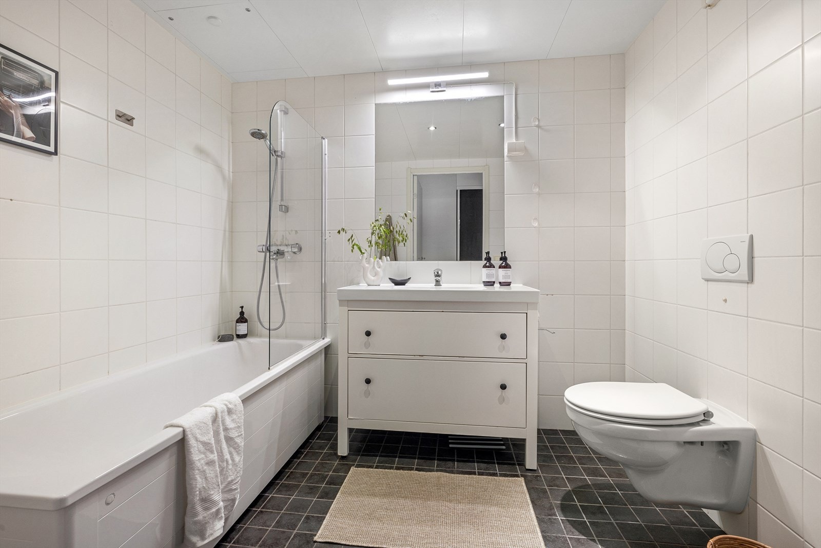 Helfliset bad med varmekabler i gulv, downlights i himling og opplegg for vaskemaskin Galleribilde