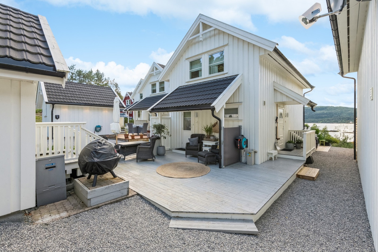 Boligens fremside har en lun fasade med plass til utemøbler. Delvis takoverbygget med direkte adkomst til kjøkken. Galleribilde