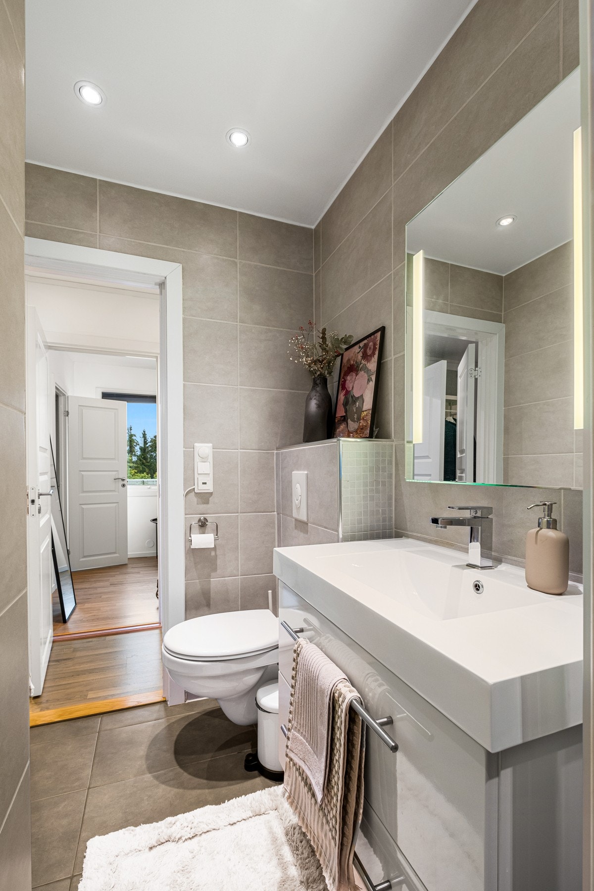 Pent, flislagt bad med gulvvarme og downlights i taket. Galleribilde
