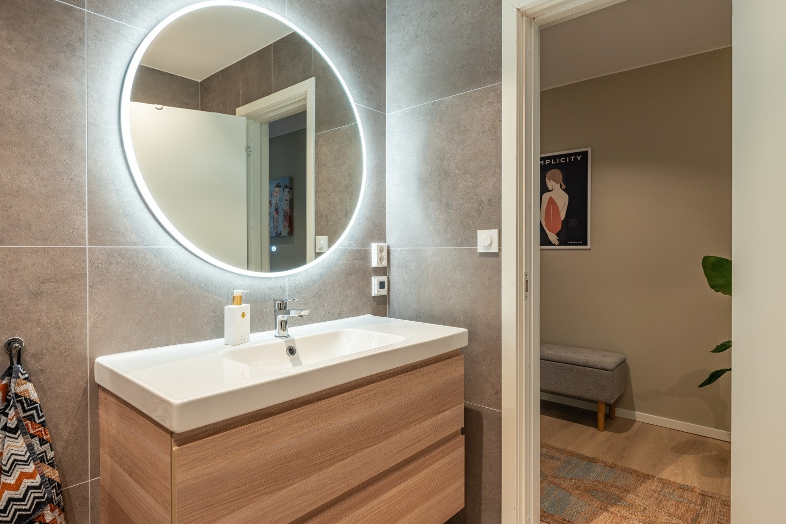 Badet består av dusjvegger av glass og krom dusjgarnityr på vegg, innredning med servant og opplegg for vaskemaskin (Kran og avløp). Galleribilde