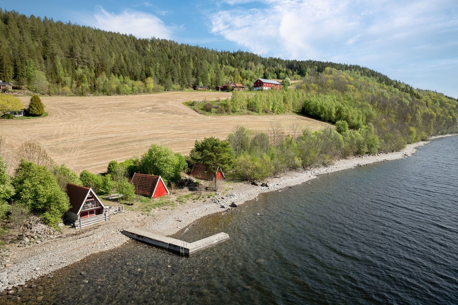 Nede ved vannkanten er det er båthus som eiendommen disponerer. Her er det også strand og brygge. Galleribilde
