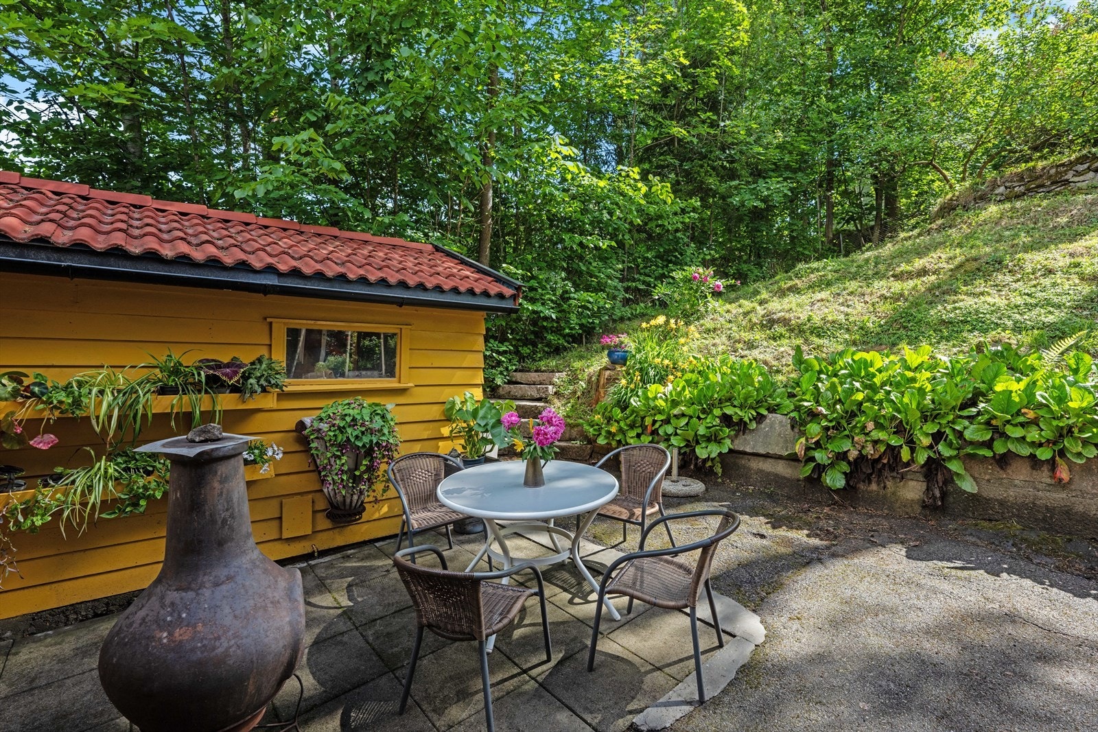 Idyllisk uteområde med sittegruppe der man kan nyte en varm sommerdag. Galleribilde