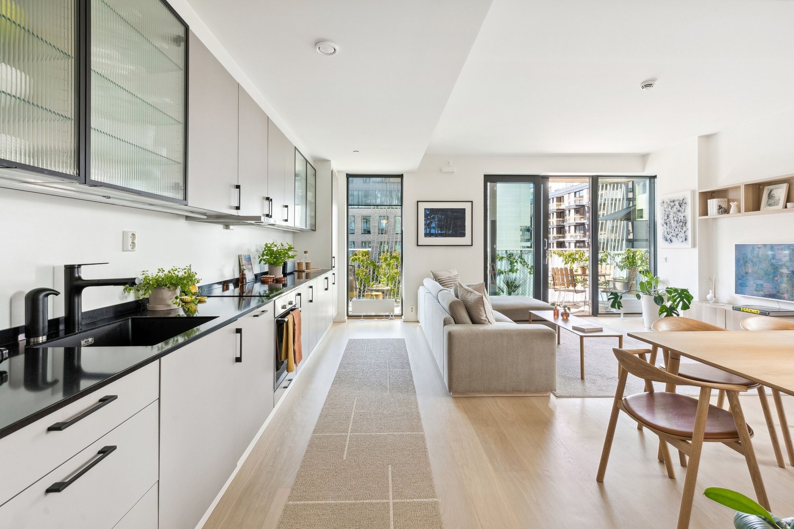 Store vindusflater gir mye lys til den åpne løsningen i stua/kjøkken Galleribilde