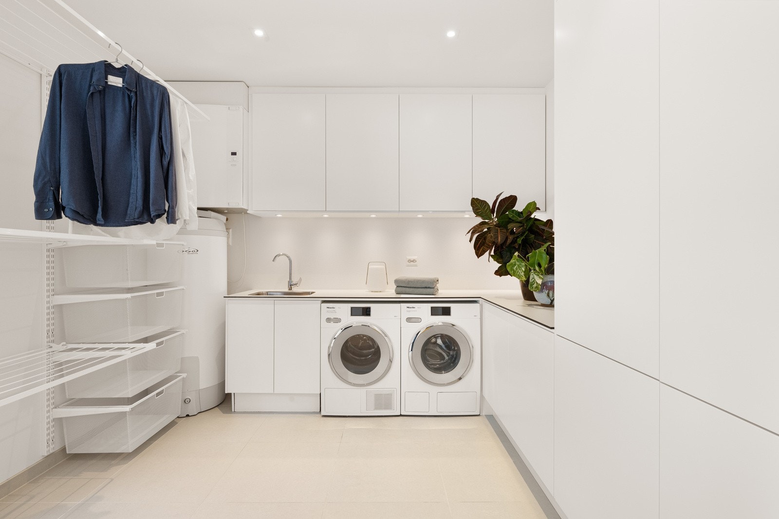 Innredningen fra Norema har hvite over- og underskap, og i en lys benkeplate er det nedfelt kum i stål Galleribilde