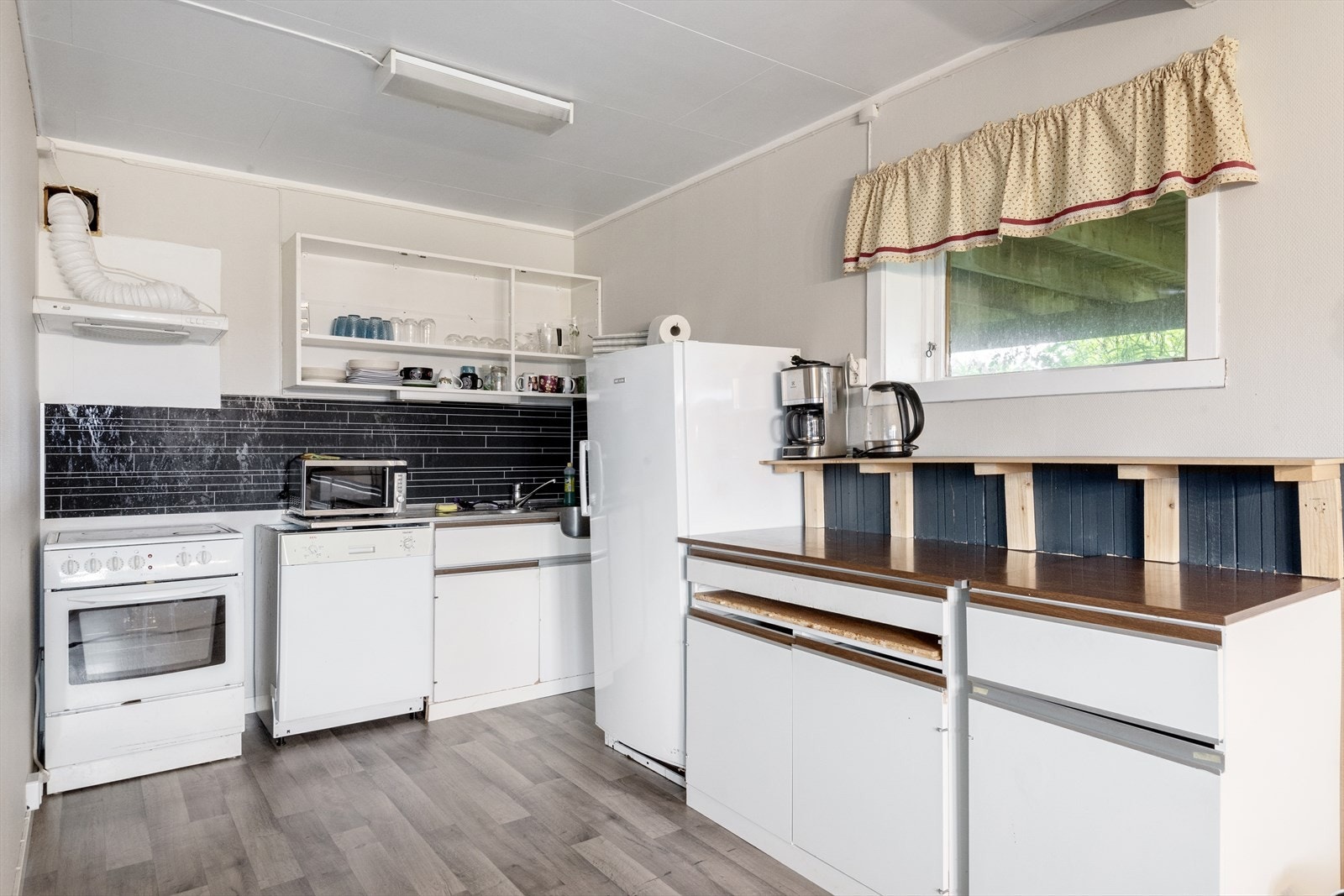 Det er montert kitchenboard på veggen over benkeplaten. Galleribilde