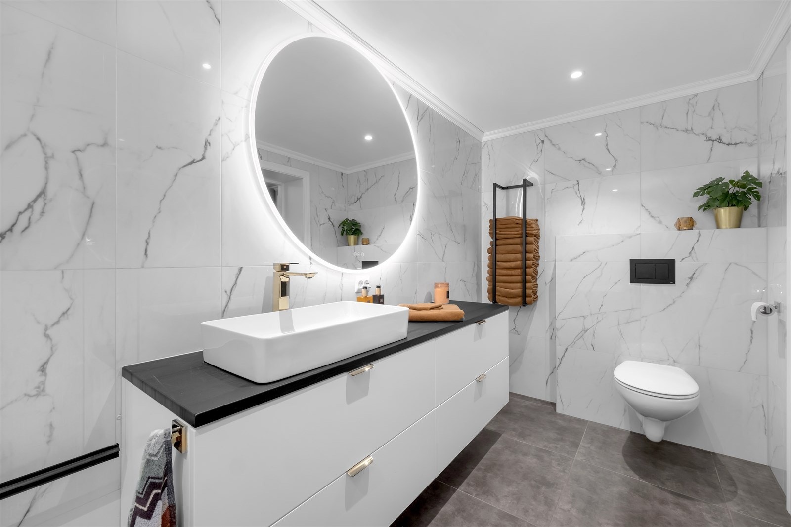 Badet har innredning med nedfelt servant, veggmontert toalett og badekar. Galleribilde