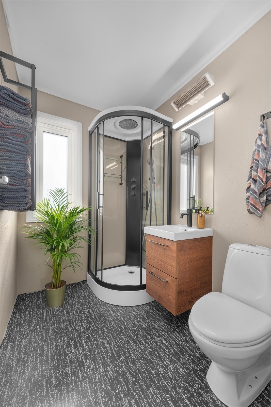 Bad med vinylbelegg på gulv. Rommet har innredning med nedfelt servant, toalett og dusjkabinett (2022). Galleribilde