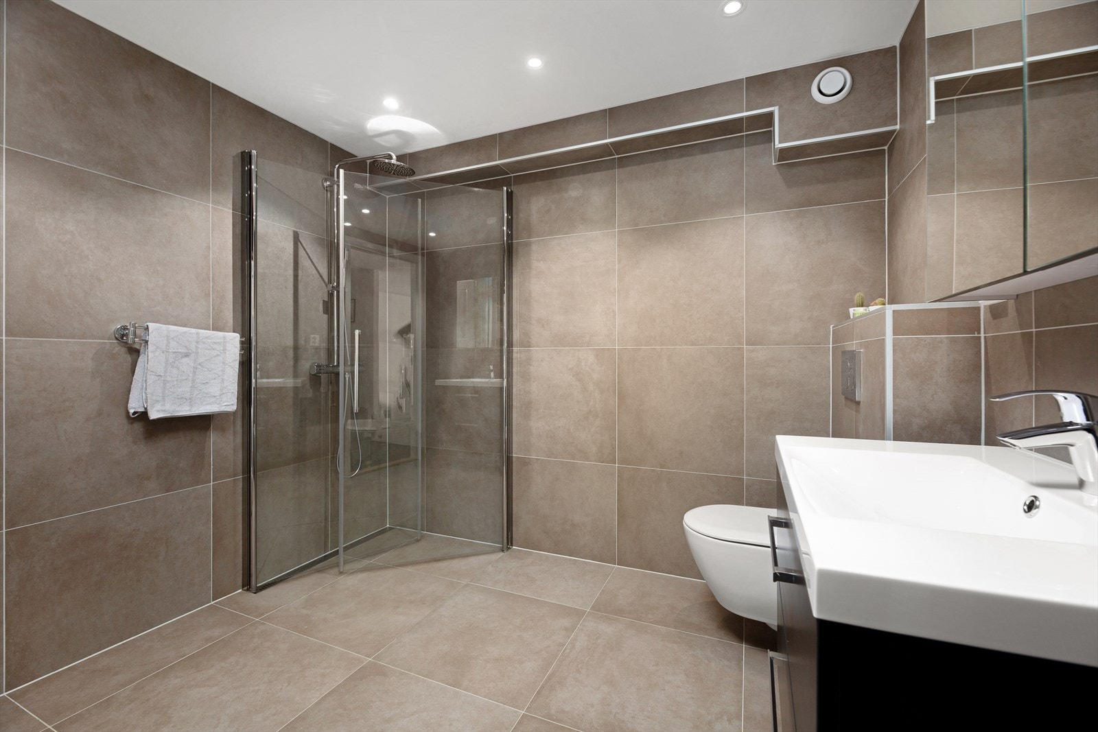 Badet ble pusset opp i 2021 og er pent flislagt på vegger og gulv med downlights i taket. Galleribilde