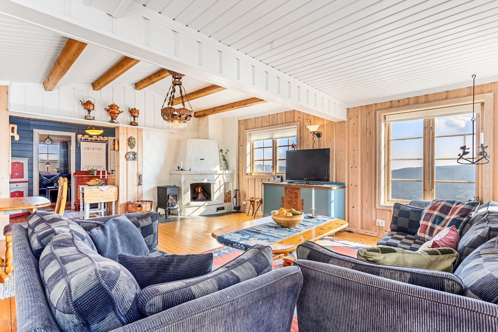 Hytta har en koselig stue med synlige bjelker i taket og vegger med flott trepanel, noe som gir rommet en sjarmerende atmosfære. Galleribilde