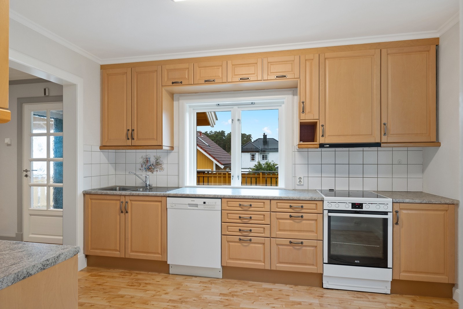 Det er god lagringsplass i innredningen og det er fliser mellom benk og overskap Galleribilde