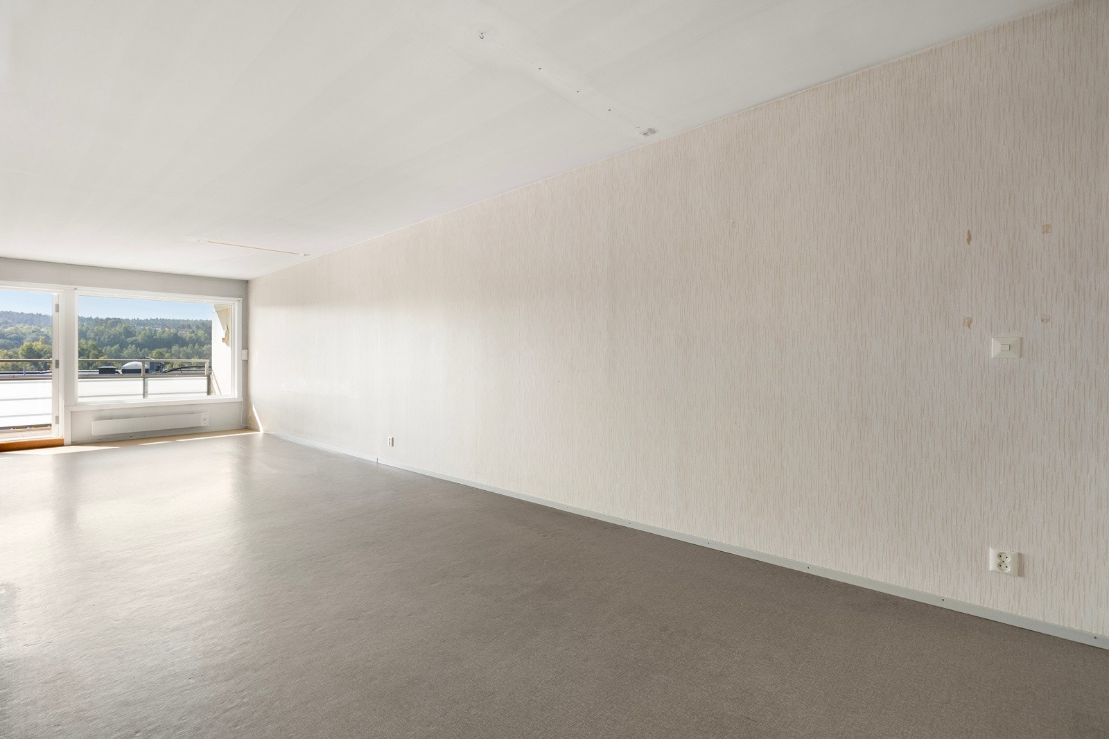 Lys og romslig stue med store vindusflater som gir mye naturlig lys. Galleribilde