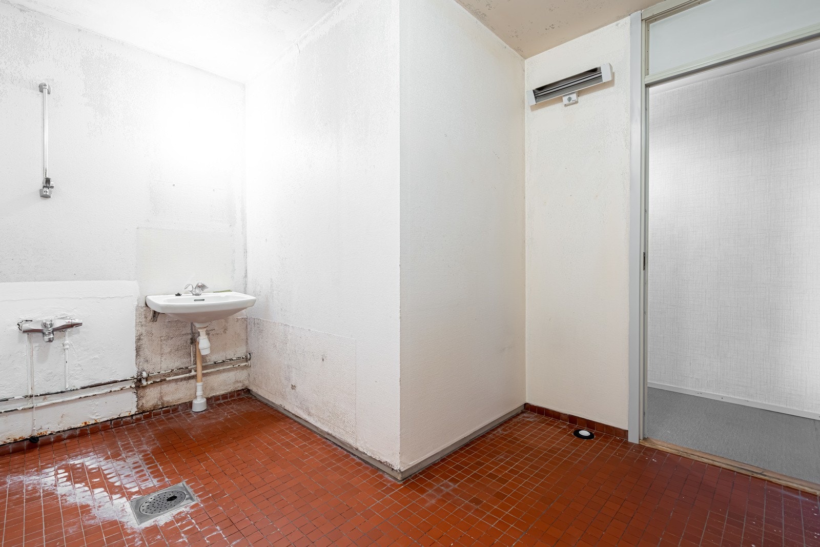 Bad fra byggeåret med sterk slitasje. Flislagt gulv. Malte vegger og himling. Galleribilde