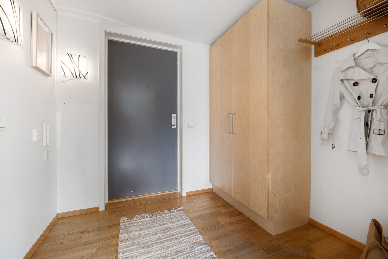 Romslig entre med garderobeskap og knagger for å henge av seg yttertøy. Galleribilde