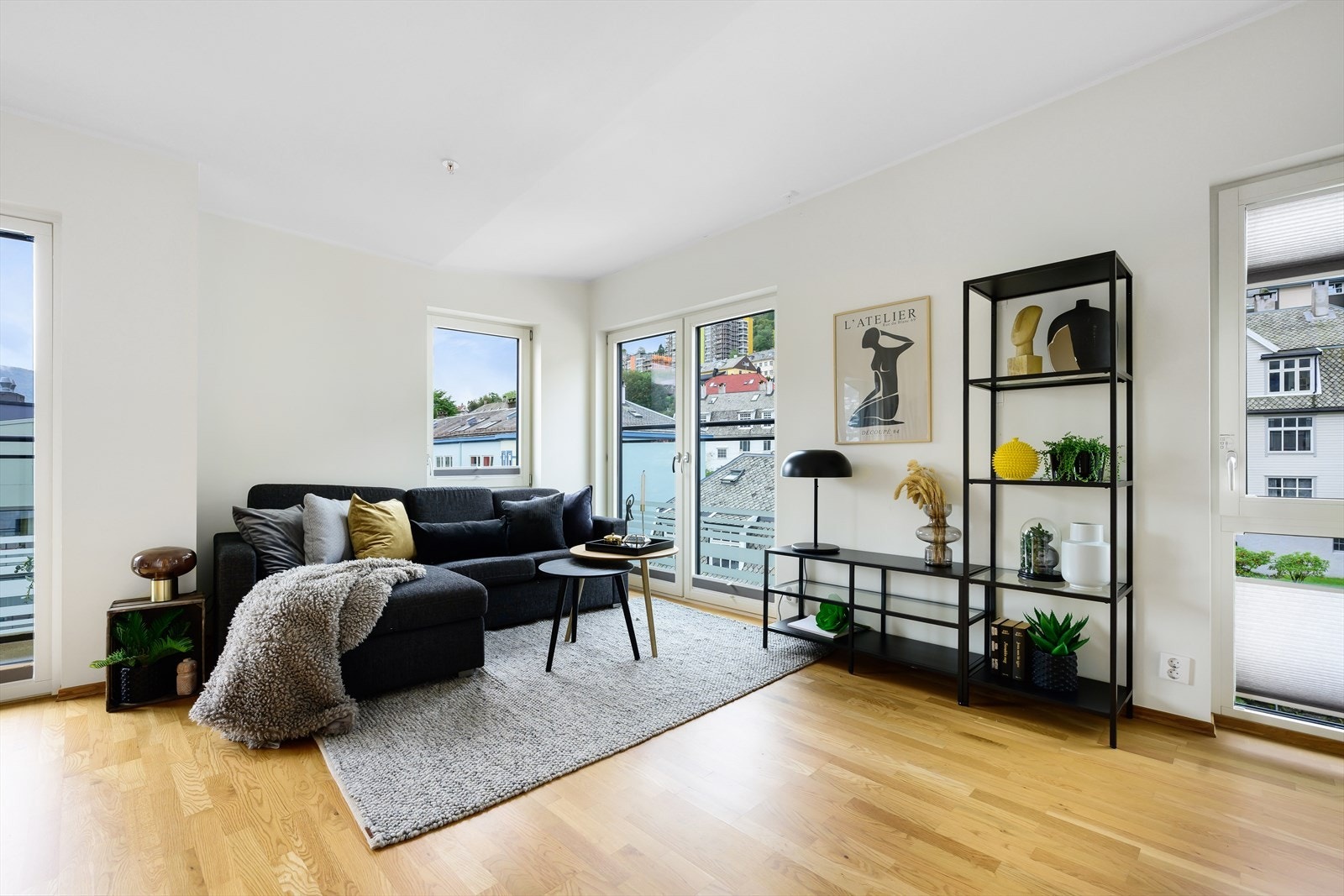 Koselig sofagruppe i hjørnet av leiligheten. Del av stue har ekstra høy himling. Galleribilde