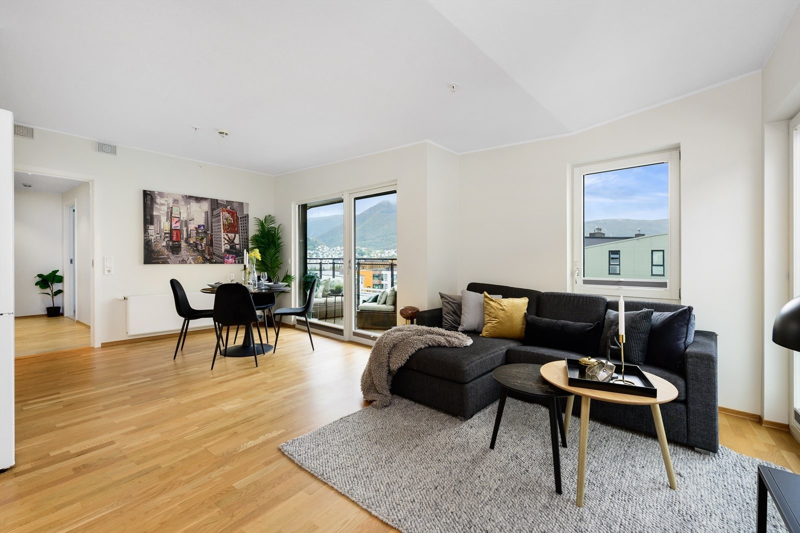 Åpen stue med store vinduer. Det er god belysning inn i leiligheten. Galleribilde