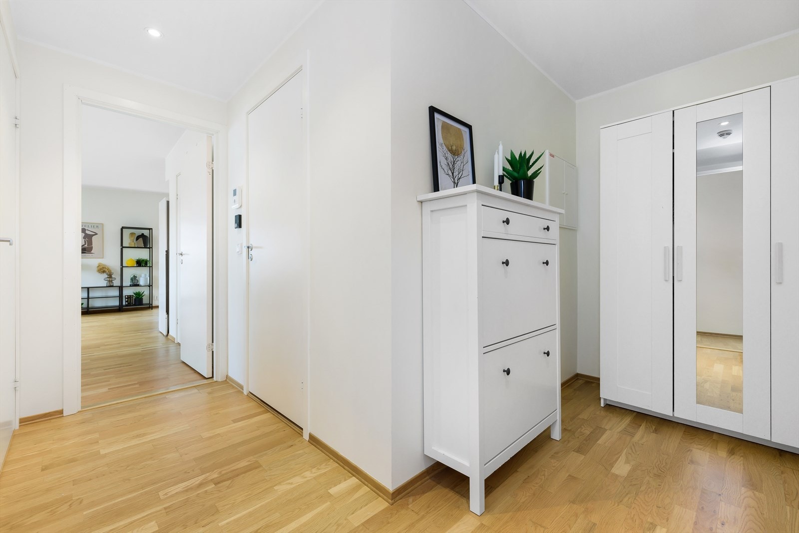 Velkommen inn i entre. Det er gjennomgående parkett i hele leiligheten. Veggene i entre har malte slette flater. Galleribilde