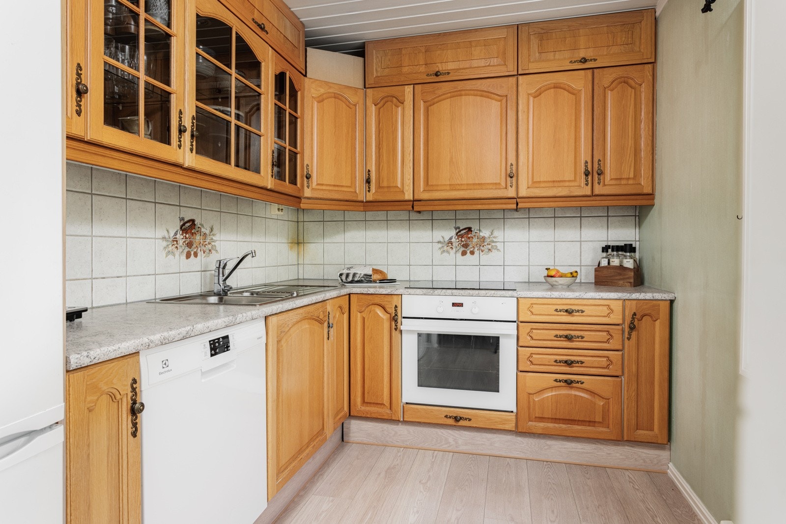 Kjøkkeninnredningen har eikefronter - her er det integrert komfyr og platetopp Galleribilde