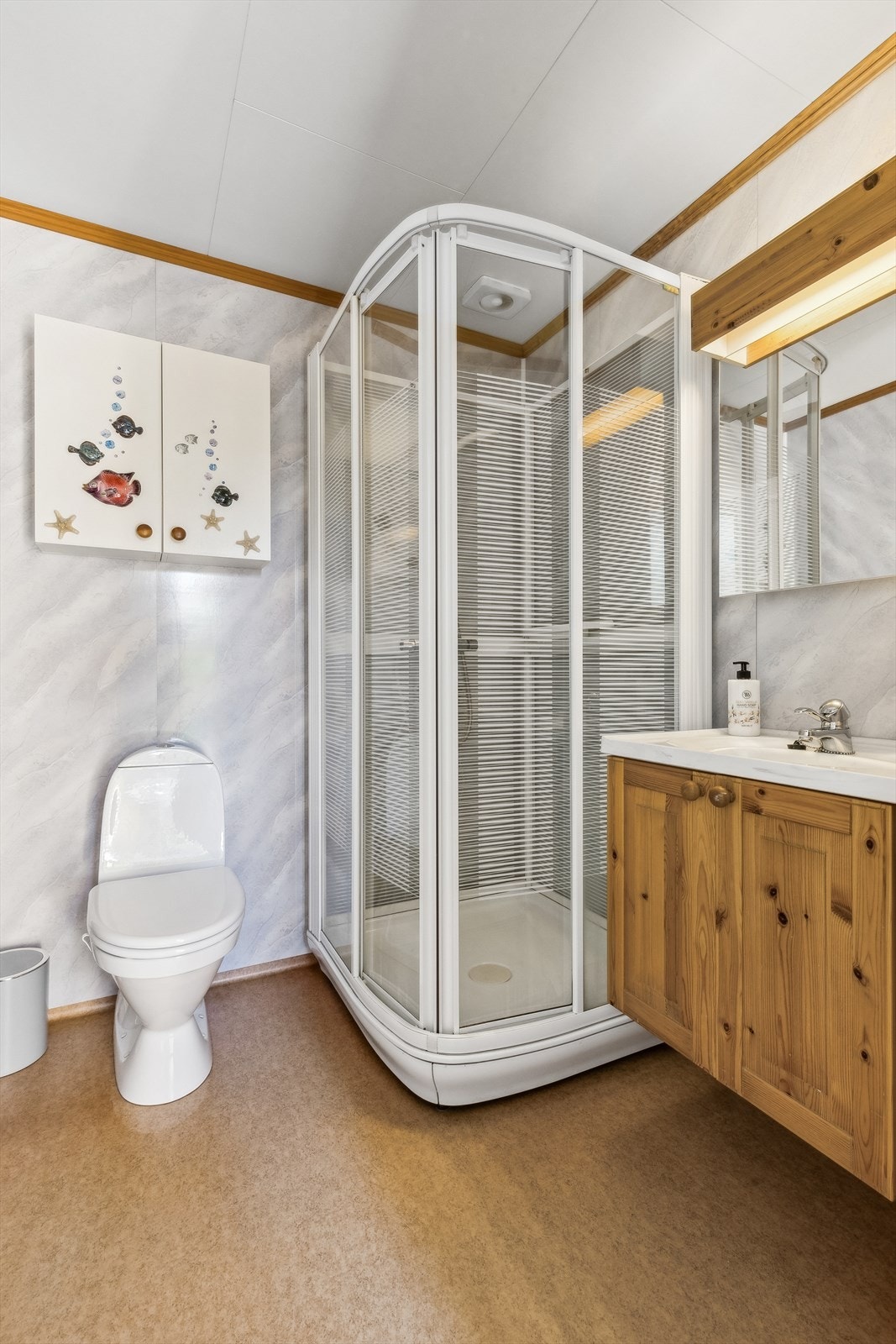 Det andre badet er av eldre stand med gulvstående toalett, dusjkabinett og baderomsinnredning med servant og ett-greps blandebatteri Galleribilde