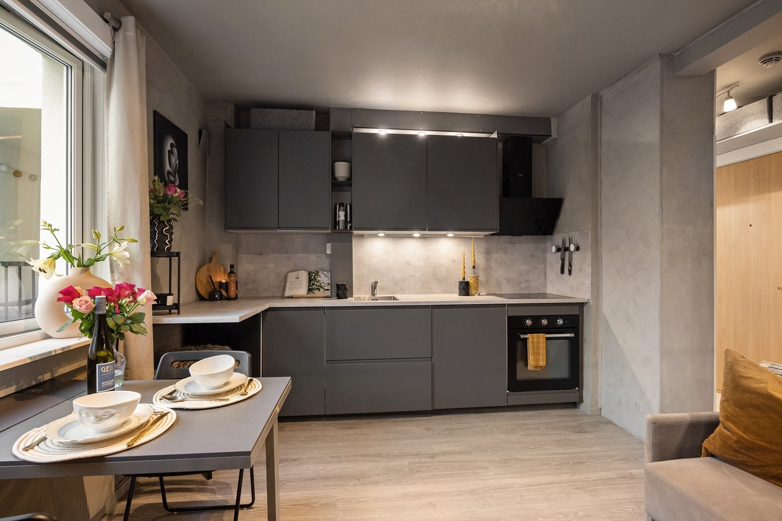 Kjøkkenet har glatte, laminerte fronter, belysning under overskapene, laminert benkeplate, kum med ettgreps blandebatteri, samt kullfiltervifte over integrert koketopp og ovn. Galleribilde