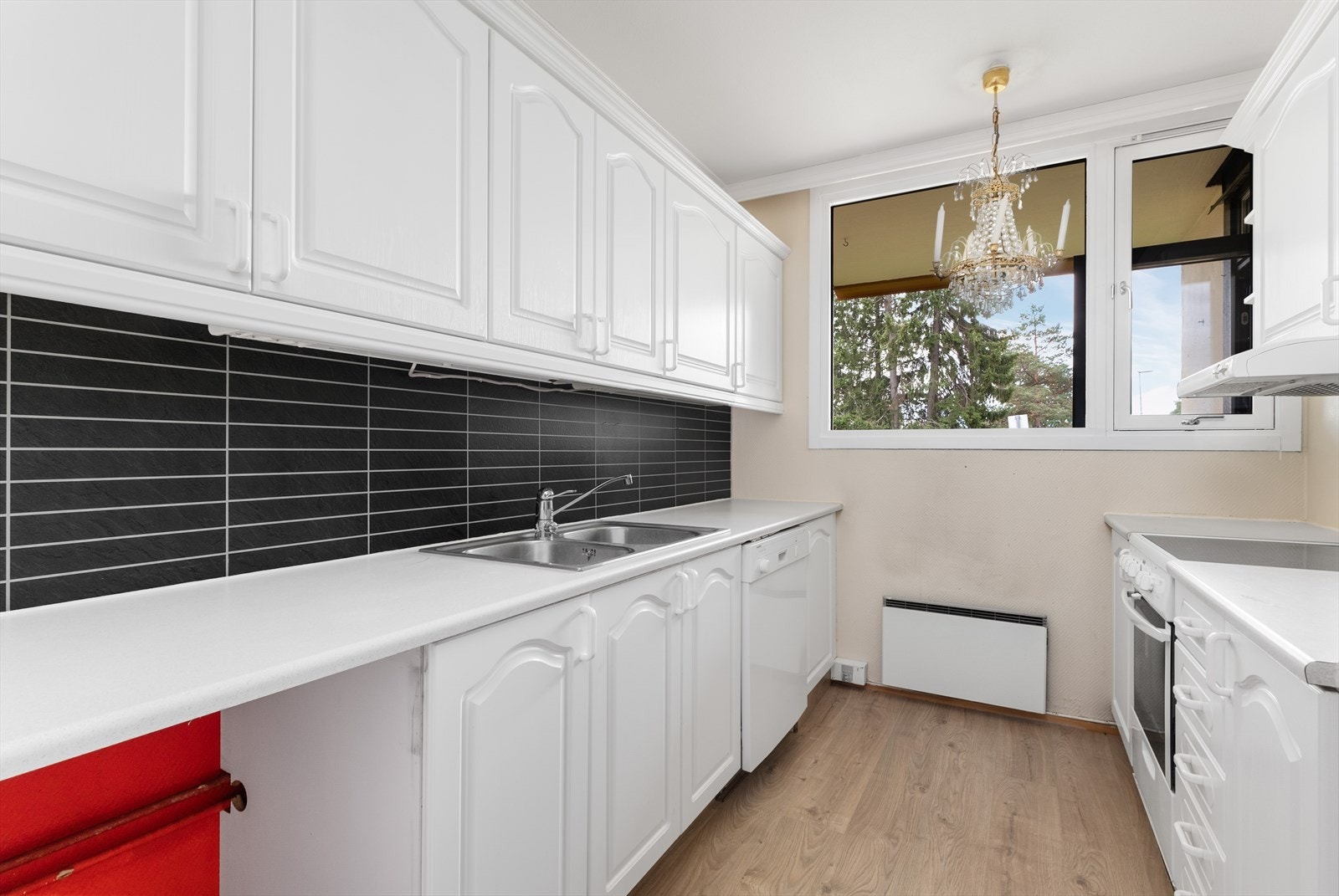 Lyst og fin kjøkken med plater over kjøkkenbenk. Galleribilde