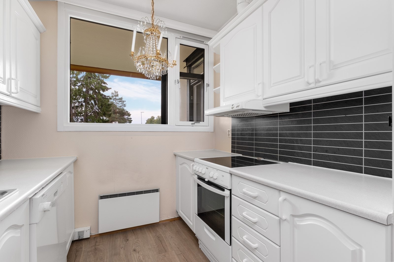 Innholdsrikt kjøkken med flere skap og godt med benkeplass. Galleribilde