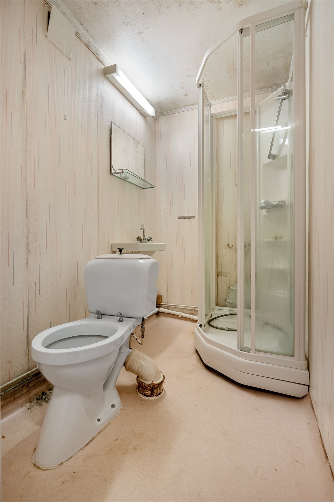 Badet er utstyrt med toalett, dusjkabinett og servant på vegg (det må påregnes full renovering av rommet) Galleribilde