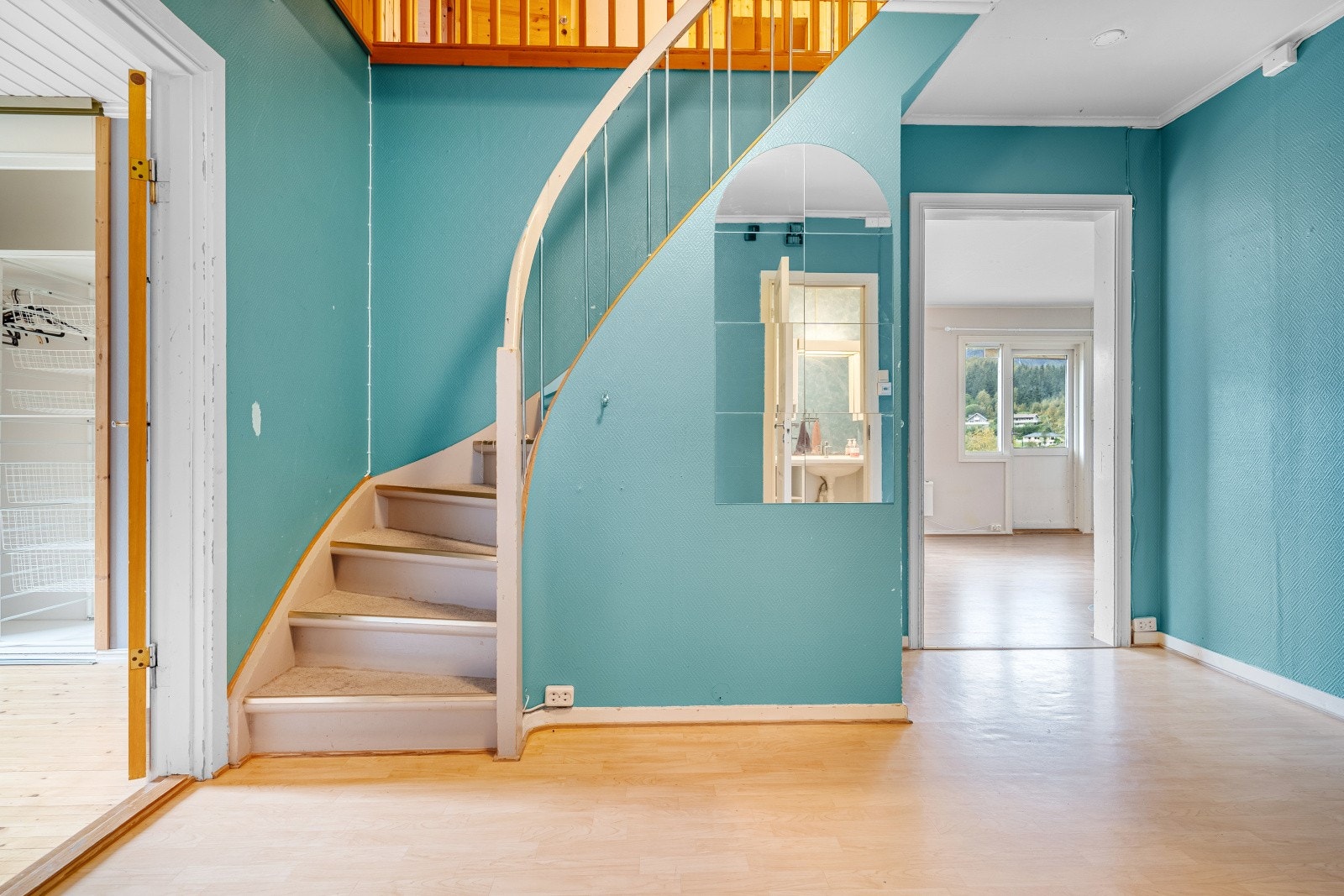 Man ønskes velkommen inn i et vindfang med plass til å henge fra seg yttertøy - Videre kommer man inn i en romslig trappegang med muligheter for ytterligere lagringsløsninger Galleribilde