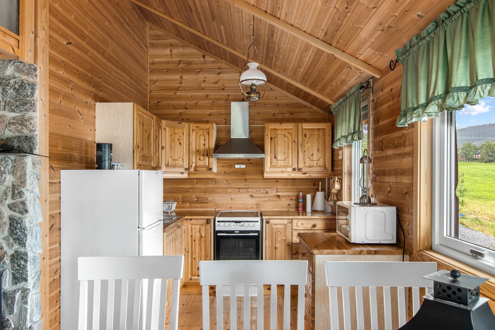 Romslig stue/kjøkken med plass for flere sittegrupper. Galleribilde