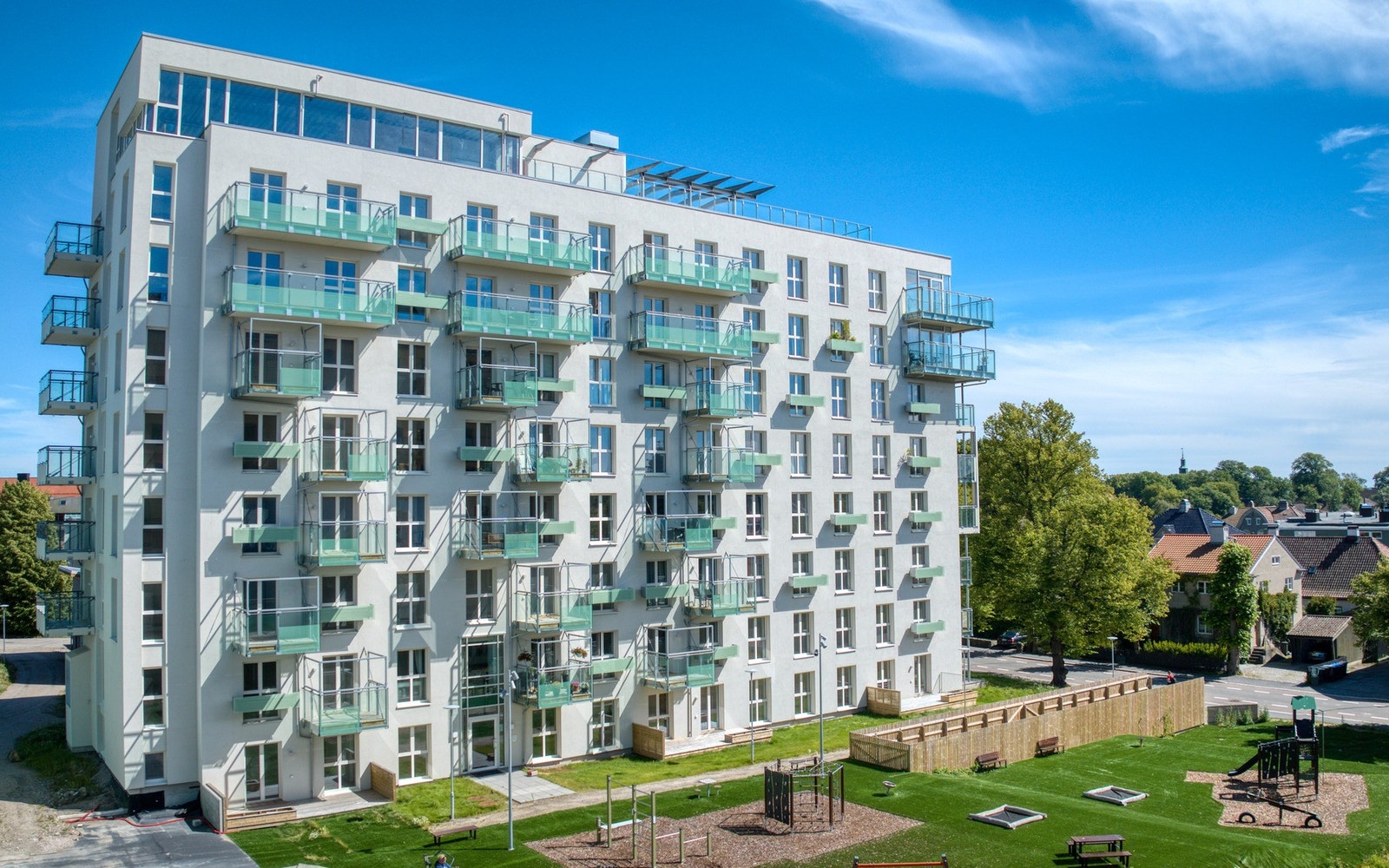 Bygget i sin helhet, du ser lekeplass og treningsapparater i front. Galleribilde